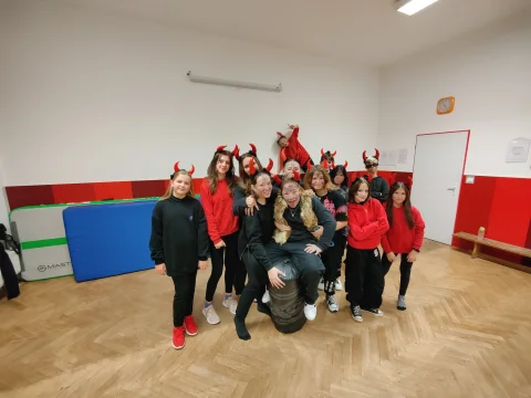 Taneční skupina v čertovských kostýmech